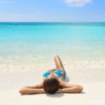 mujer tomando el sol en la  playa