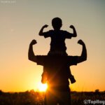 padre con su hijo cargado jugando al heroe